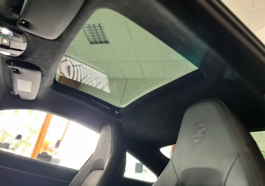 Vue intérieure du toit ouvrant et des sièges avant en cuir noir embossé Porsche d'une 911 Carrera S argent GT 2019