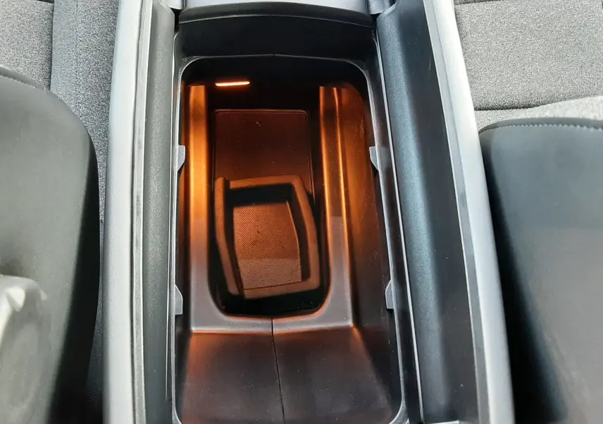 Vue plongeante sur le rangement central intérieur éclairé, entouré de sièges en tissu gris du Citroën C5 Aircross 2021.