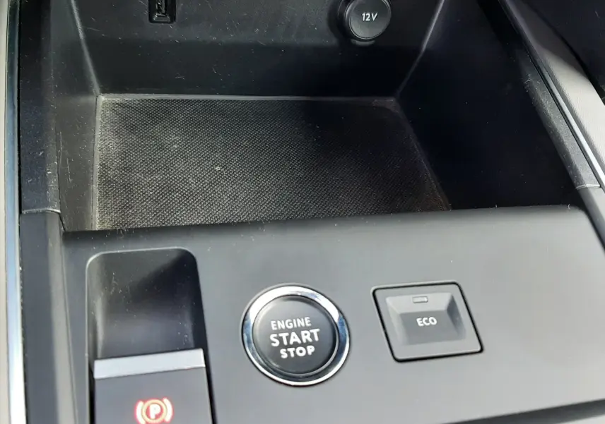 Gros plan sur la console centrale noire du Citroën C5 Aircross 2021 avec bouton start/stop, frein électrique et prise 12V.