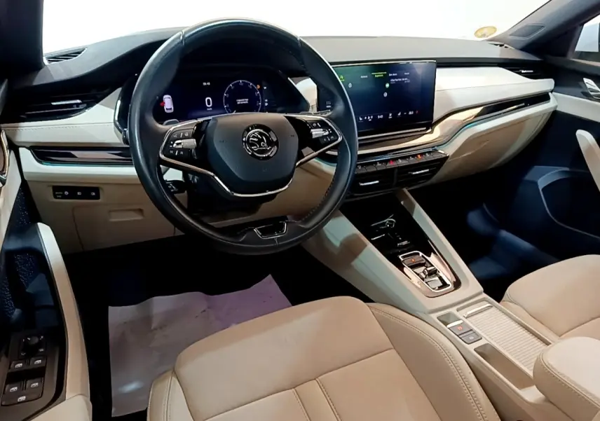 Intérieur beige clair de la Skoda Octavia 2022 vu côté conducteur, avec tableau de bord digital et écran tactile central.
