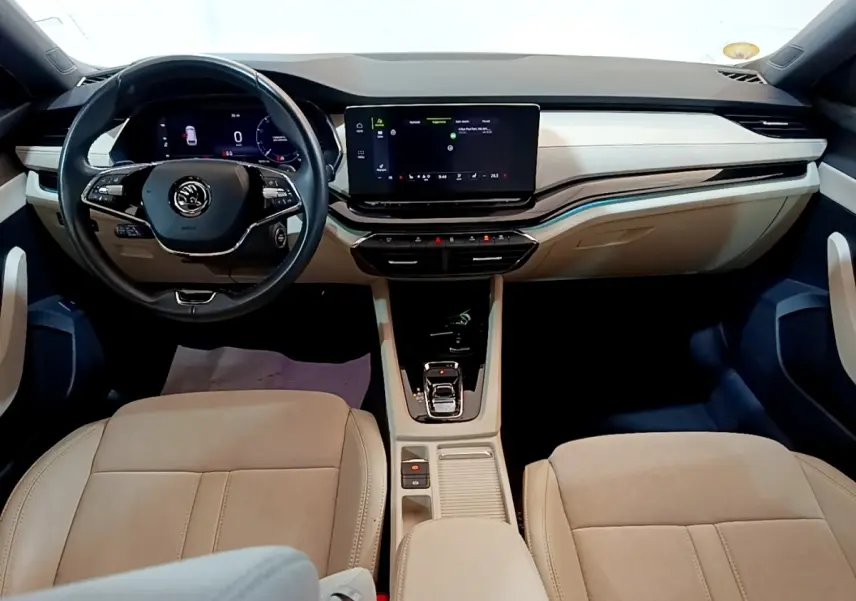 Intérieur beige clair de la Skoda Octavia 2022, vue frontale sur tableau de bord et volant multifonction noir.