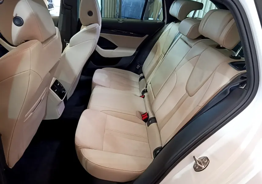 Vue intérieure côté droit des sièges arrière beige clair d'une Skoda Octavia blanche 2022 avec appuie-têtes réglables.