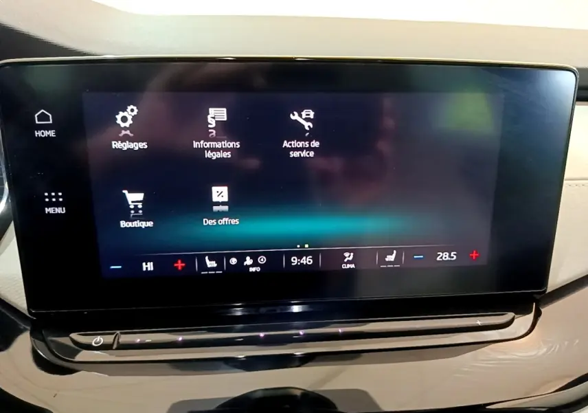 Écran tactile central noir affichant le menu de réglages dans l'habitacle beige d'une Skoda Octavia 2022.