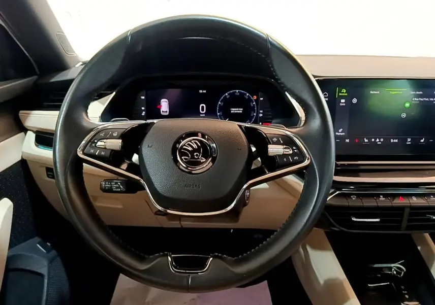 Vue intérieure centrée sur le volant noir de la Skoda Octavia 2022 avec tableau de bord digital et écran tactile.