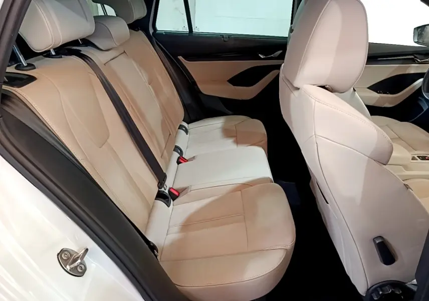 Vue intérieure côté droit montrant les sièges arrière beige clair d'une Skoda Octavia blanche 2022 Style.