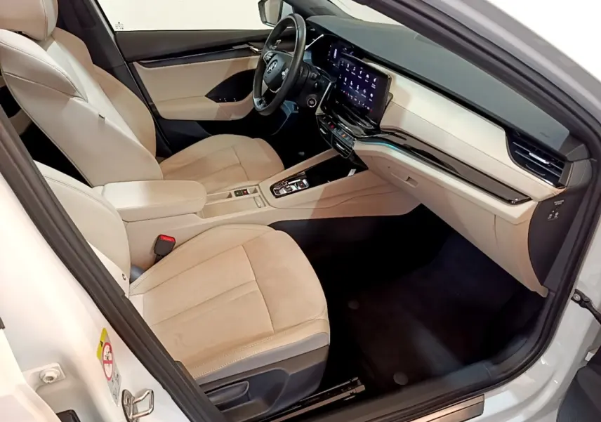 Intérieur côté conducteur d’une Skoda Octavia blanche 2022 avec sièges beige et écran tactile central.