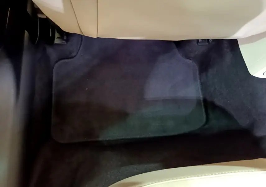 Vue rapprochée du tapis de sol noir sous le siège avant beige d'une Skoda Octavia blanche 2022.