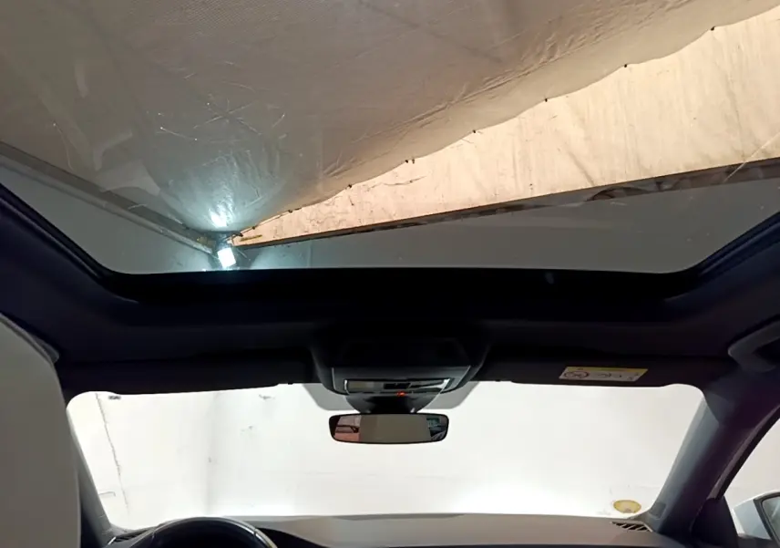 Vue intérieure du toit ouvrant panoramique et tableau de bord noir de la Skoda Octavia blanche 2022.