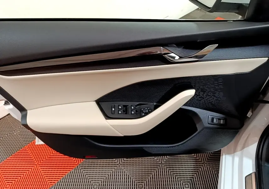 Vue intérieure du panneau de porte côté conducteur blanc et beige avec commandes électriques sur Skoda Octavia 2022.