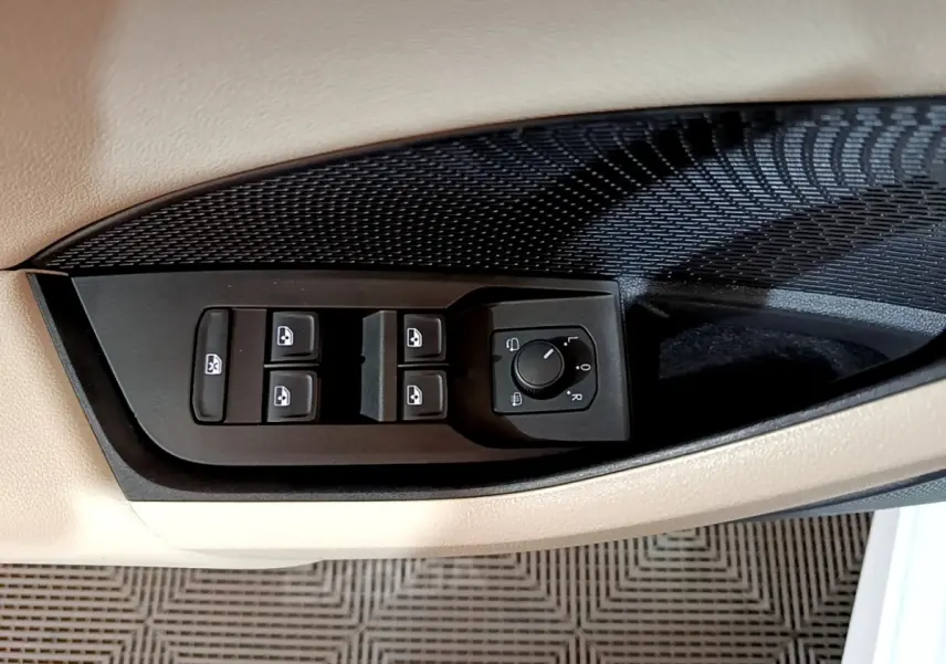 Gros plan sur les commandes des vitres et rétroviseurs côté conducteur d'une Skoda Octavia blanche 2022.