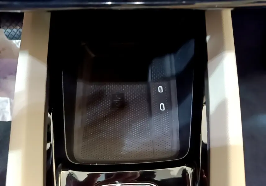 Gros plan sur la zone de recharge sans fil noire au centre de la console d'une Skoda Octavia blanche 2022.