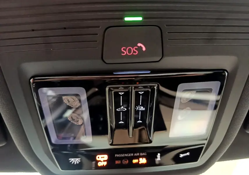Gros plan sur la console de plafonnier noire avec bouton SOS rouge et commandes d’éclairage dans une Skoda Octavia blanche 2022.