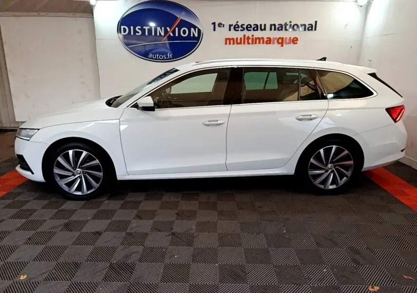 Profil latéral gauche d'une Skoda Octavia blanche 2022 en break, avec jantes alliage et vitres teintées.