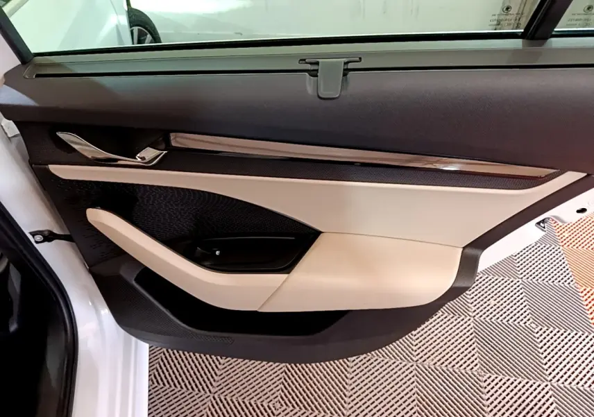 Gros plan sur la porte côté gauche blanche d'une Skoda Octavia 2.0 TDI 150 DSG7 Style avec garniture beige et noire.