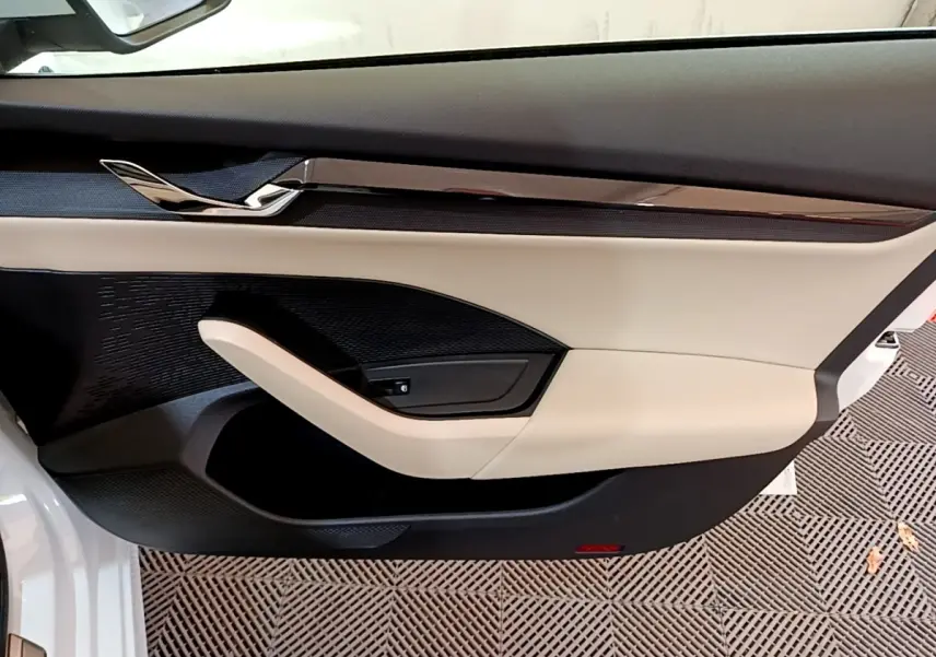 Vue rapprochée de la porte avant gauche blanche d'une Skoda Octavia 2022 avec garniture beige et noire élégante.