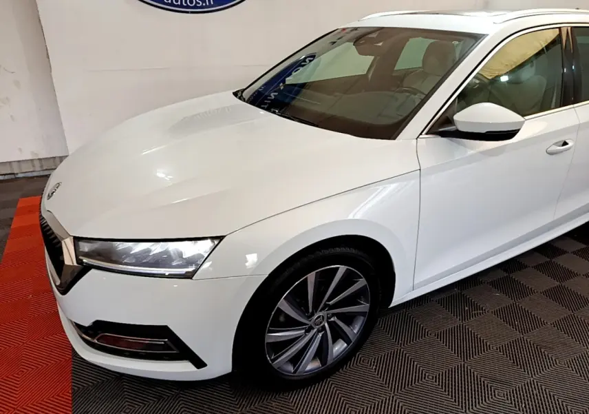 Vue 3/4 avant droit d'une Skoda Octavia blanche 2022 avec jantes alliage et phares LED distinctifs.