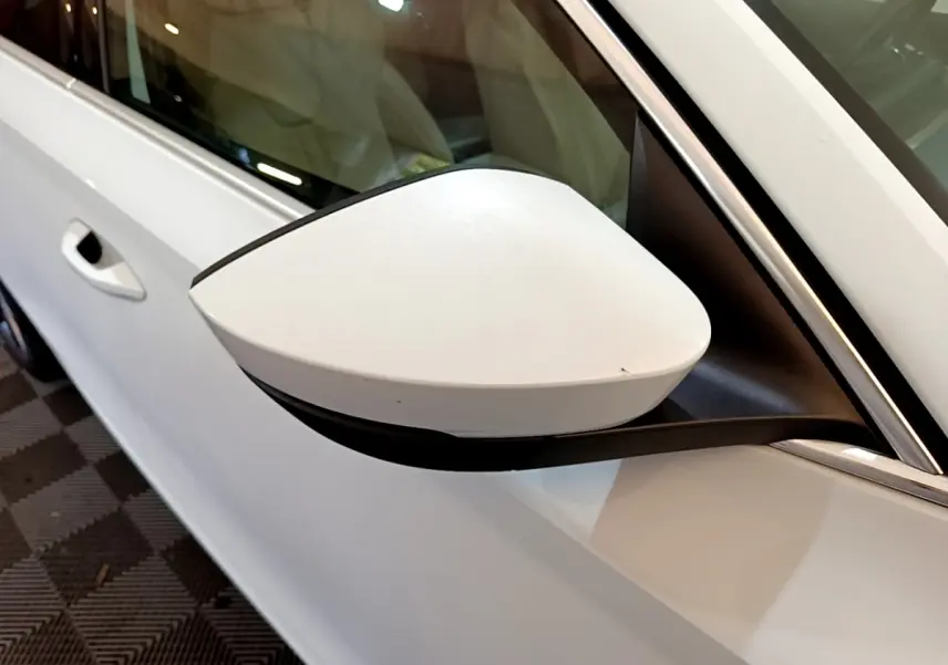 Rétroviseur blanc côté gauche d'une Skoda Octavia 2.0 TDI 150 DSG7 Style 2022, vue rapprochée sur porte et vitre.