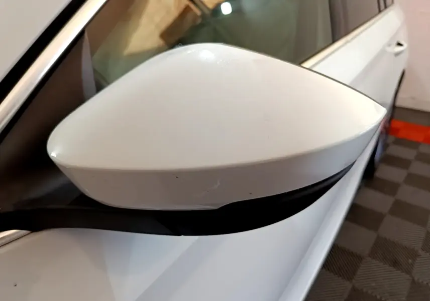 Rétroviseur blanc côté gauche en gros plan d'une Skoda Octavia 2.0 TDI 150 DSG7 Style 2022 blanche.