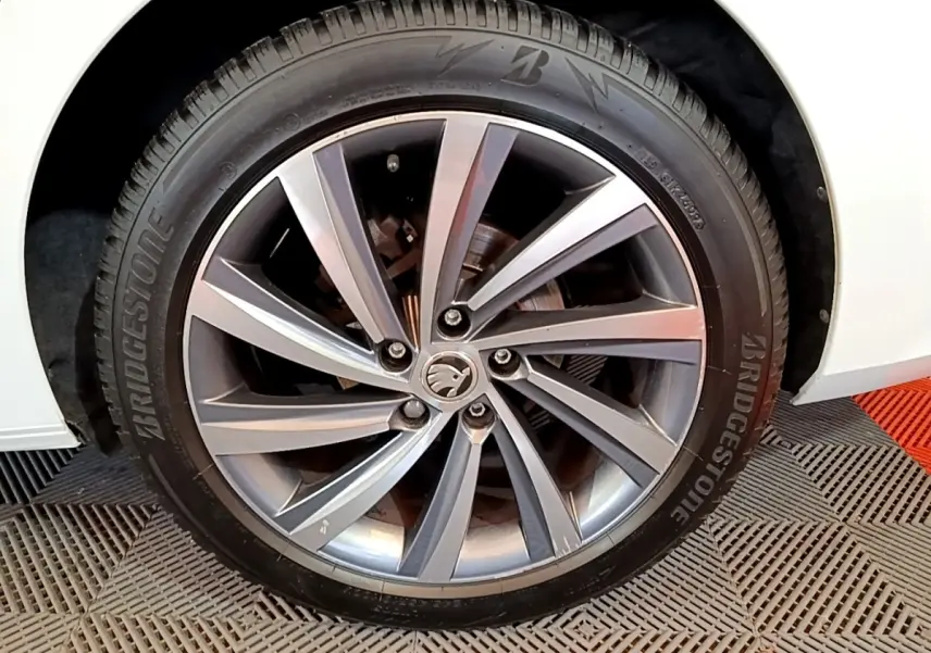 Gros plan sur la roue avant droite blanche d'une Skoda Octavia 2.0 TDI 150 DSG7 Style avec jante alliage gris et pneu Bridgestone.