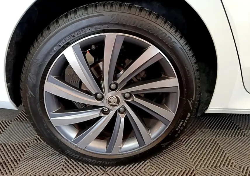 Gros plan sur la roue avant droite d'une Skoda Octavia blanche 2022 avec jante alliage et pneu Bridgestone.