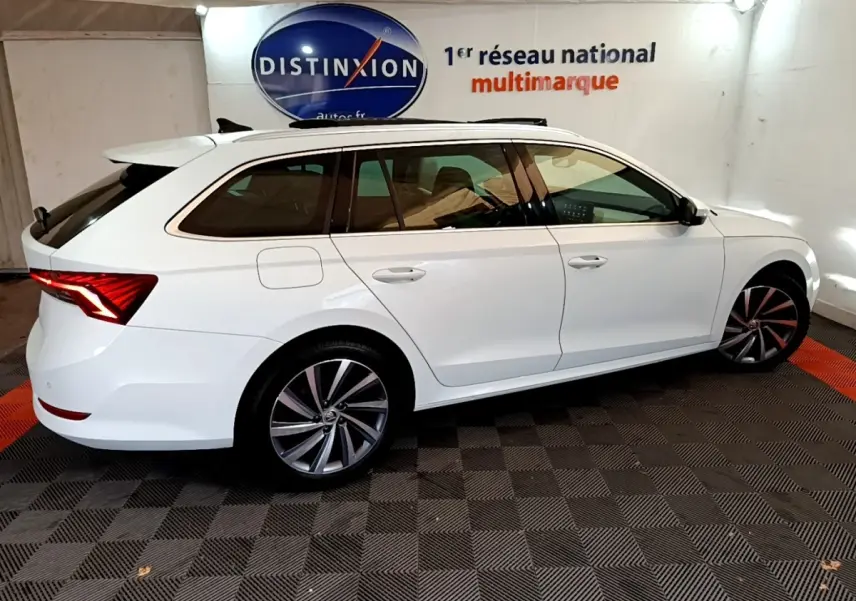 Vue latérale droite d'une Skoda Octavia break blanche 2022 avec jantes alliage et feux arrière LED distinctifs.