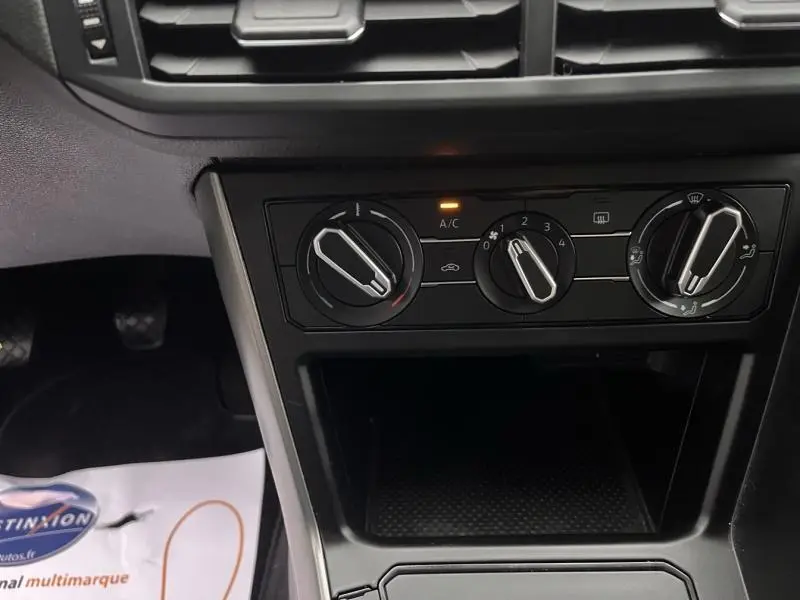 Vue rapprochée des commandes de climatisation sur la console centrale d'une Volkswagen Polo gris Urano 2021.