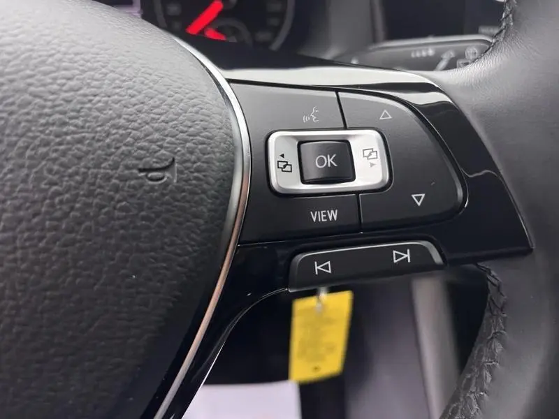 Gros plan sur les commandes multifonctions à droite du volant cuir d'une Volkswagen Polo gris Urano 2021.