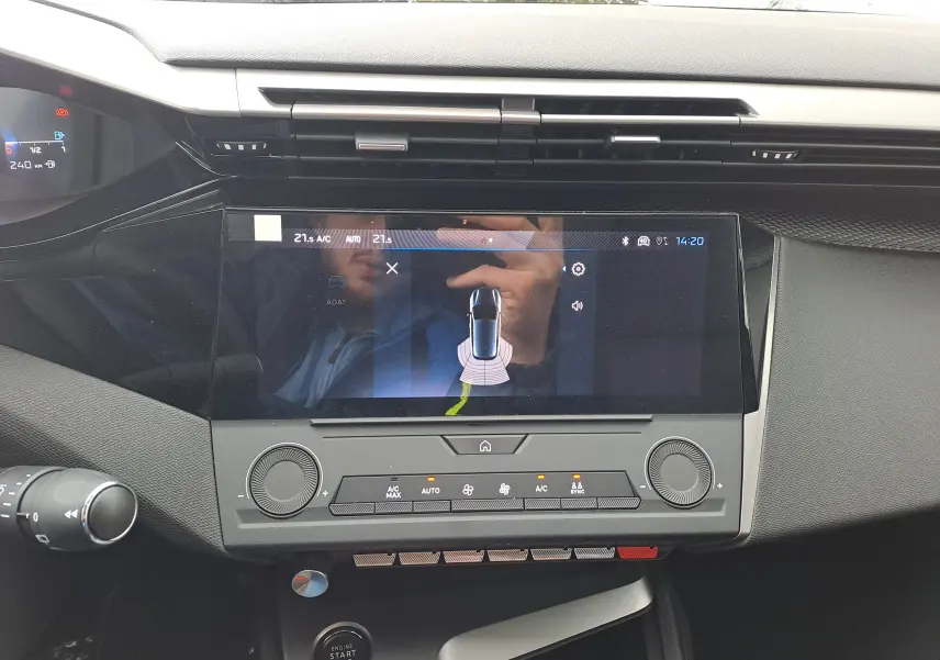 Vue rapprochée de la console centrale de la Peugeot 308 2025, écran tactile affichant l'aide au stationnement.