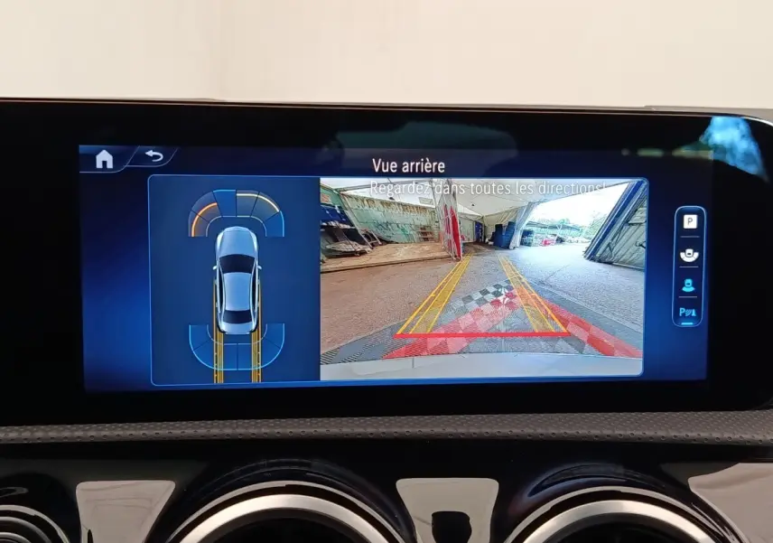 Écran tactile intérieur montrant la caméra de recul et l’aide au stationnement d’une Mercedes Classe A 250 e hybride.