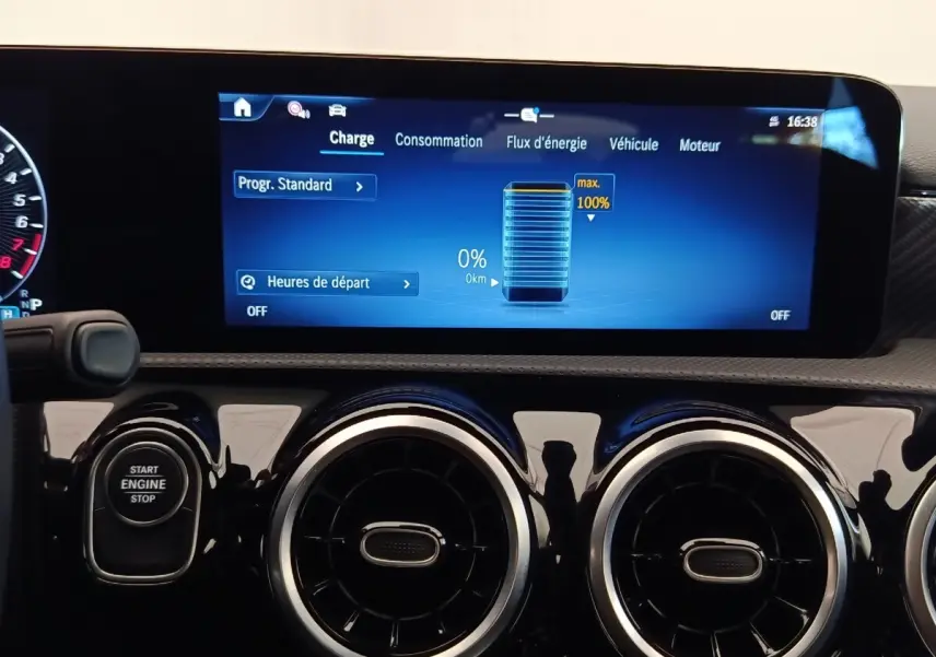Tableau de bord de Mercedes Classe A 250 e Hybrid, écran tactile affichant la charge batterie à 0%, boutons ronds noirs.