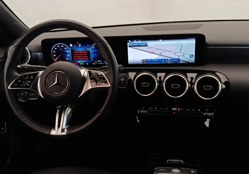 Vue intérieure frontale du tableau de bord de la Mercedes Classe A 250 e Hybrid avec écran tactile large et volant multifonctions.