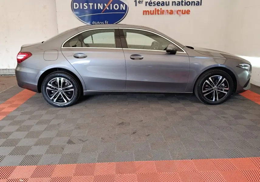 Profil côté gauche d'une Mercedes Classe A 250 e Hybrid gris foncé, avec jantes alliage et feux arrière LED visibles.