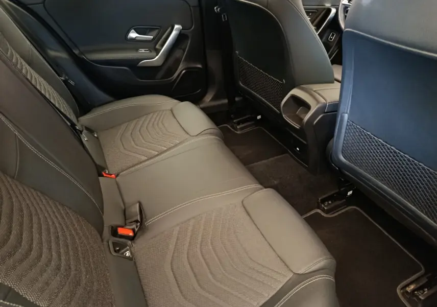 Vue intérieure arrière côté droit de la Mercedes Classe A 250 e Hybrid gris foncé, montrant la banquette et les dossiers des sièges avant.