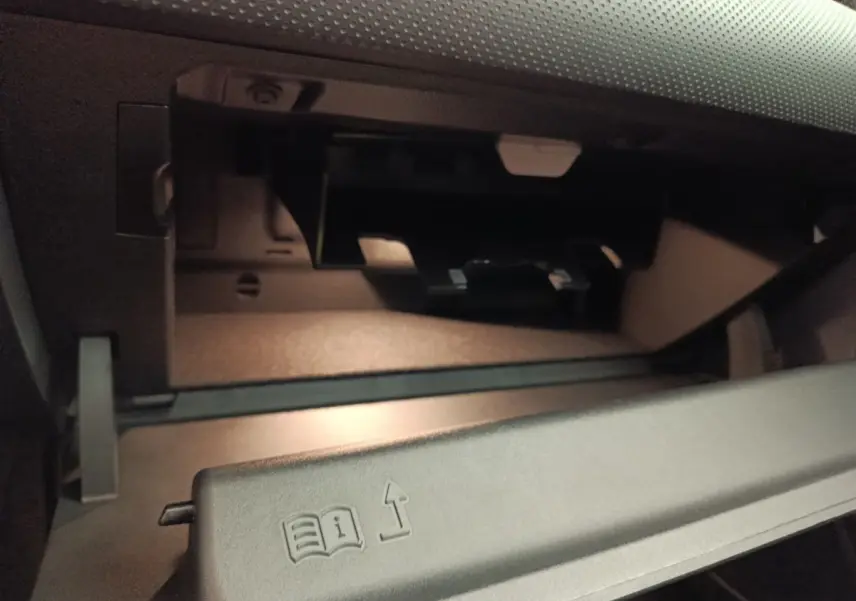 Vue rapprochée de la boîte à gants ouverte dans l’habitacle gris foncé de la Mercedes Classe A 250 e Hybrid 2024.