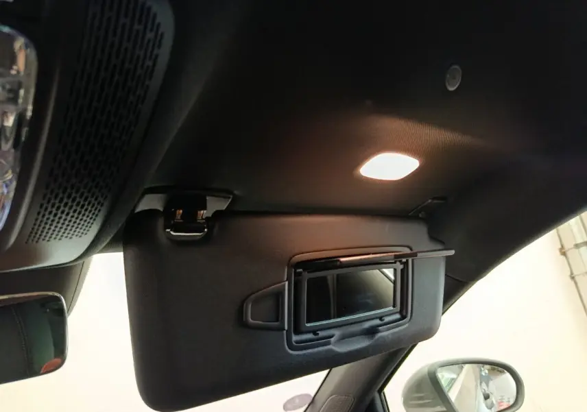 Détail intérieur du pare-soleil côté conducteur avec miroir éclairé et rétroviseur extérieur gris foncé d'une Mercedes Classe A 250 e Hybrid.