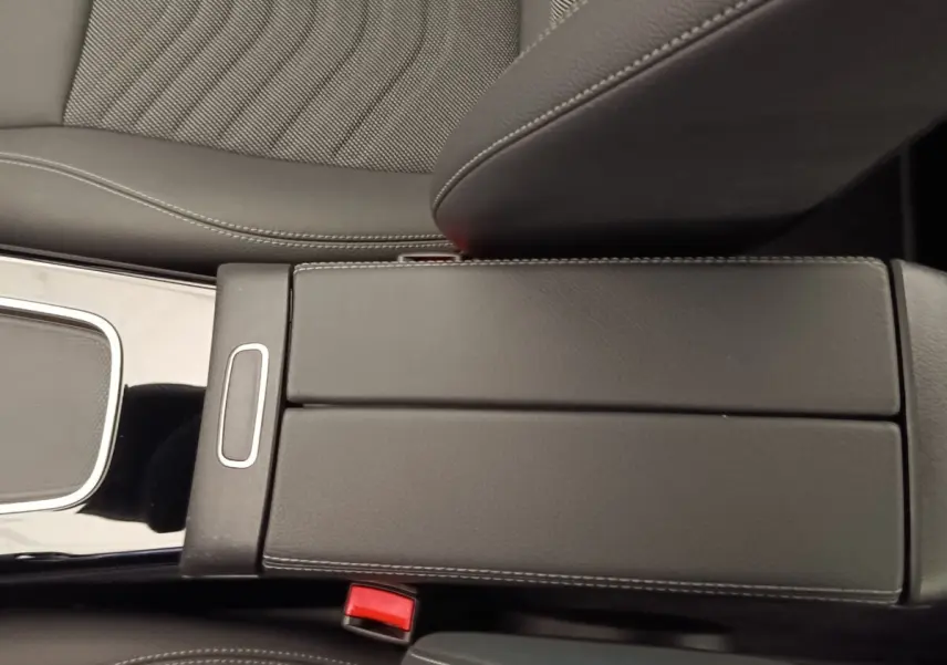 Gros plan sur l'accoudoir central en cuir noir avec surpiqûres blanches de la Mercedes Classe A 250 e Hybrid 2024.