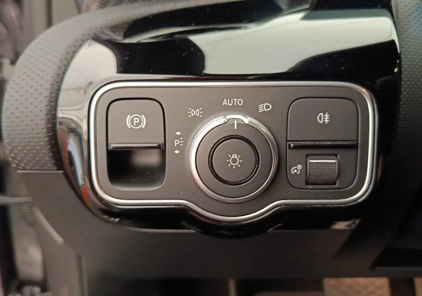 Gros plan sur le panneau de commandes d’éclairage et frein à main électrique de la Mercedes Classe A 250 e hybride 2024.