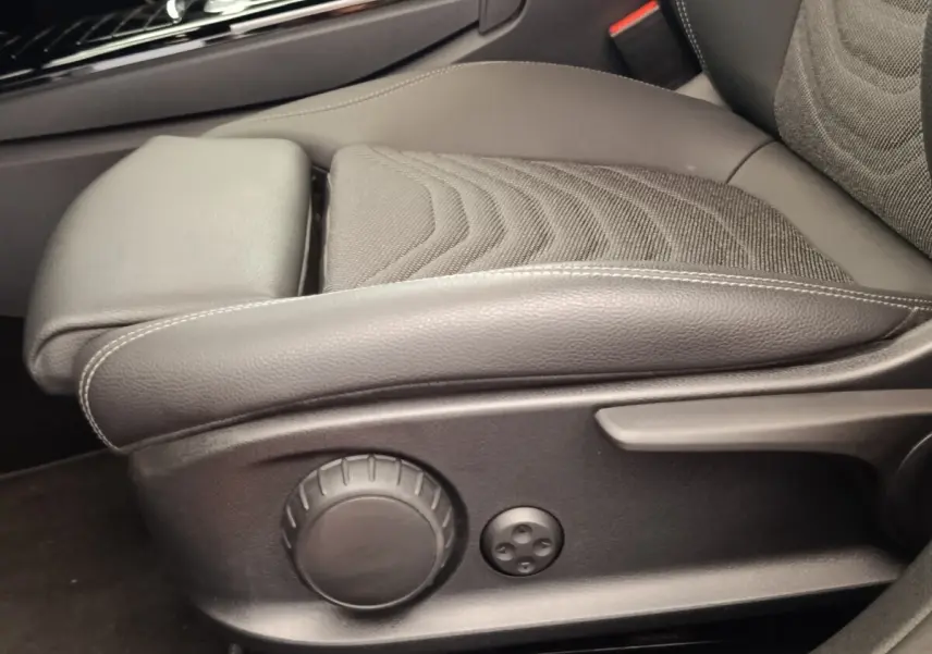Gros plan sur le siège avant gris foncé de la Mercedes Classe A 250 e Hybrid avec commandes de réglage manuelles.