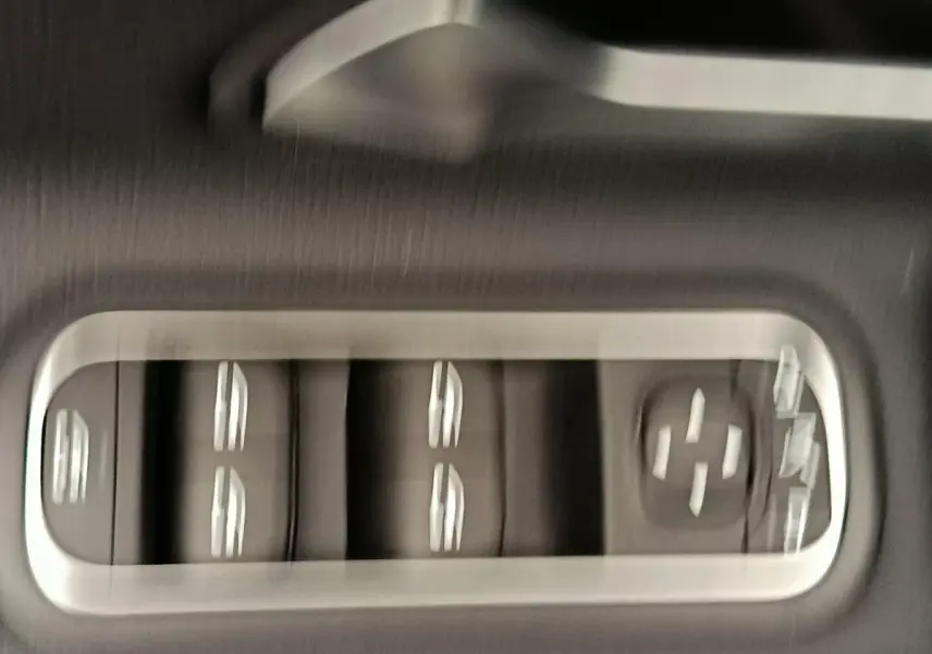 Gros plan sur les commandes de lève-vitres et réglages des rétroviseurs côté conducteur de la Mercedes Classe A 250 e hybride.