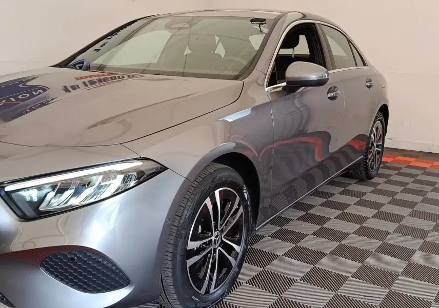 Mercedes Classe A 250 e hybride gris foncé vue 3/4 avant droit avec jantes alliage et phares LED allumés.