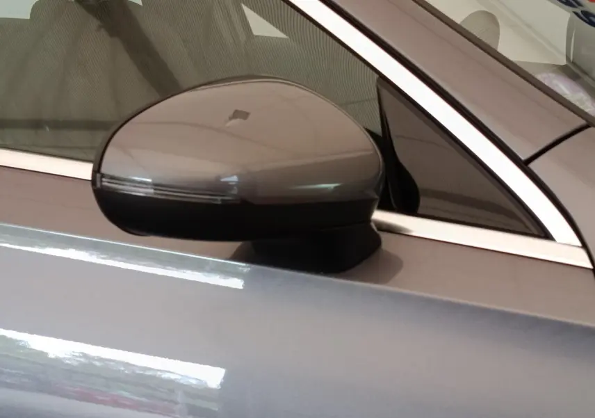 Rétroviseur côté conducteur gris foncé de la Mercedes Classe A 250 e Hybrid EQ Berline 2024, vue rapprochée.