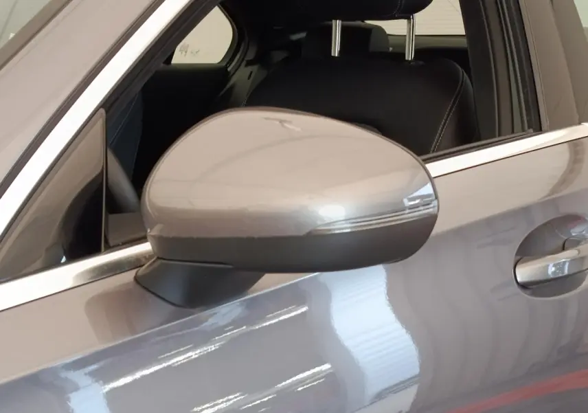 Gros plan sur le rétroviseur côté gauche gris foncé d'une Mercedes Classe A 250 e Hybrid Berline 2024.