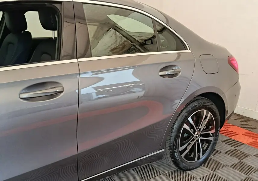 Vue latérale droite d'une Mercedes Classe A 250 e Hybrid gris foncé, mettant en valeur la jante alliage et les poignées de porte.