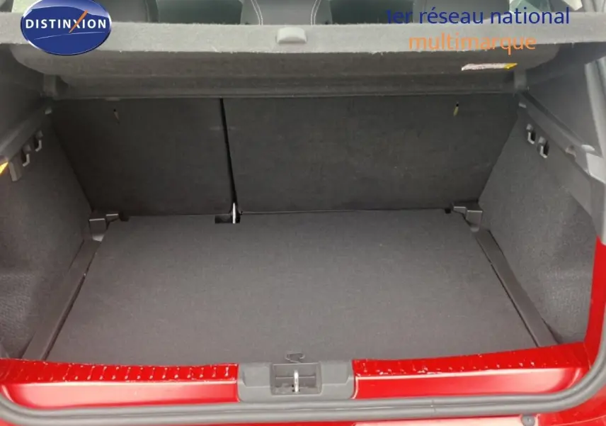 Coffre ouvert vu de l'arrière d'une Dacia Sandero Stepway rouge fusion métal, montrant l'espace de chargement vide.