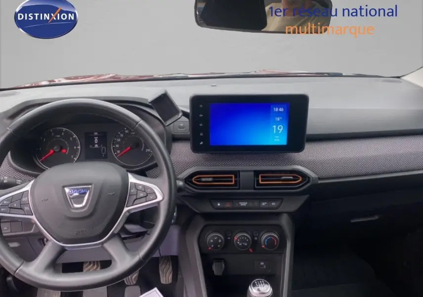 Vue intérieure frontale du tableau de bord et volant noir du Dacia Sandero Eco-G 2022, avec écran tactile central allumé.