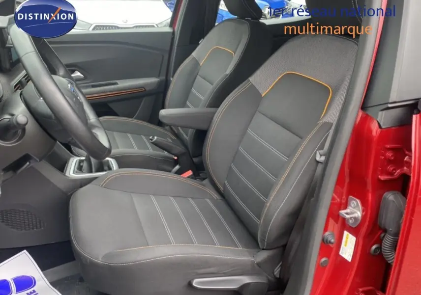 Vue intérieure côté gauche des sièges avant noirs avec surpiqûres orange d'une Dacia Sandero rouge fusion métal 2022.