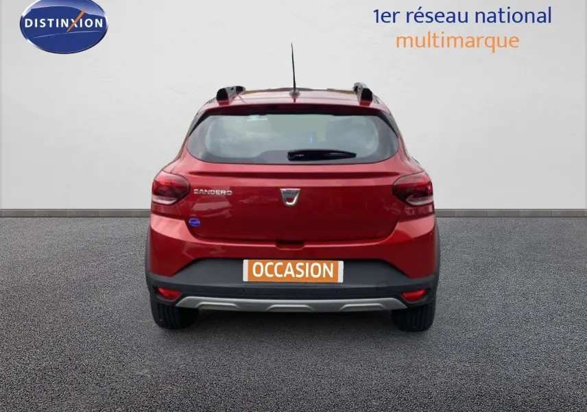 Vue arrière d'une Dacia Sandero Stepway rouge fusion métal avec logo et plaque occasion visible.