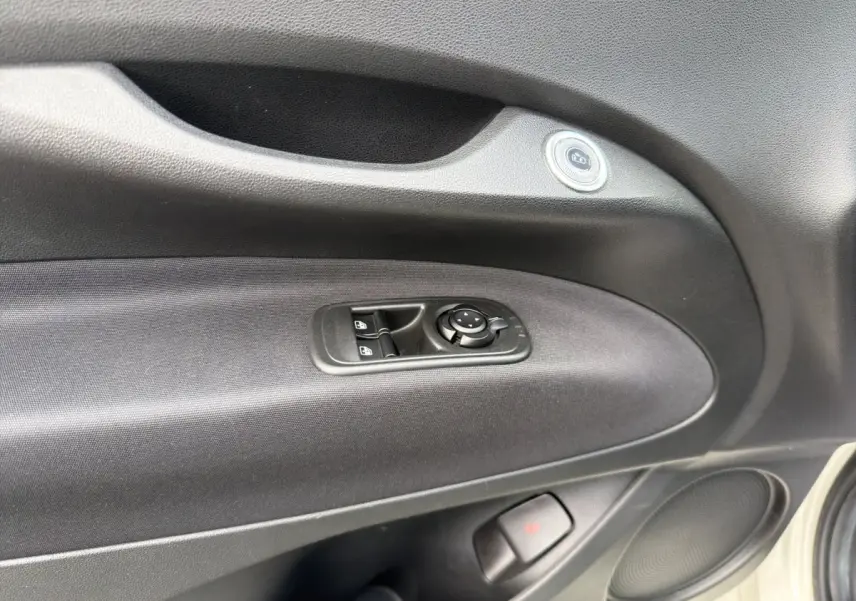 Détail de la porte côté conducteur de la FIAT 500 blanche 2023 avec commandes de vitres et rétroviseurs électriques.