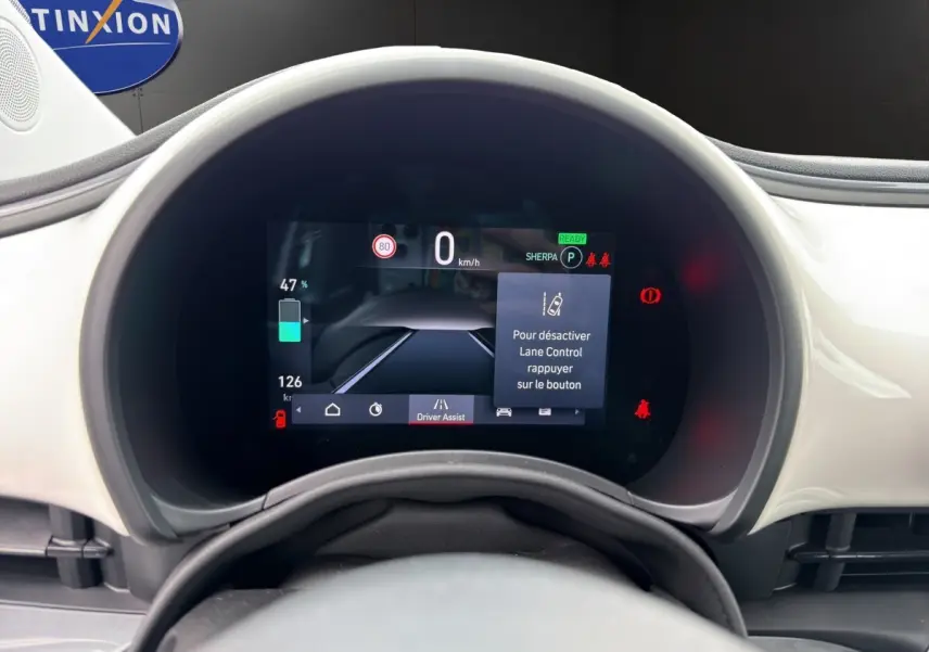 Vue rapprochée du combiné d'instruments numérique de la Fiat 500 blanche 2023, affichant l'assistance au maintien de voie.