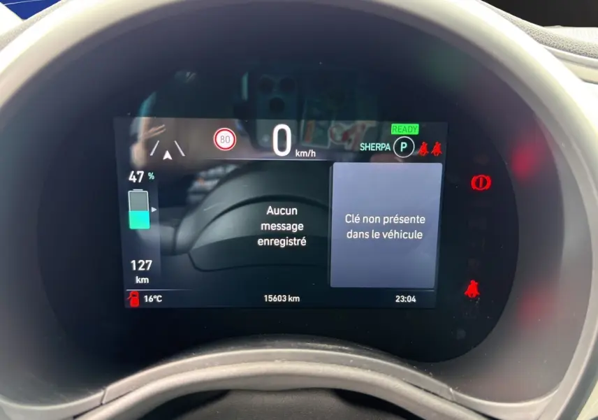 Affichage numérique du combiné d'instruments de la Fiat 500 électrique, avec indication batterie à 47% et messages d'alerte.